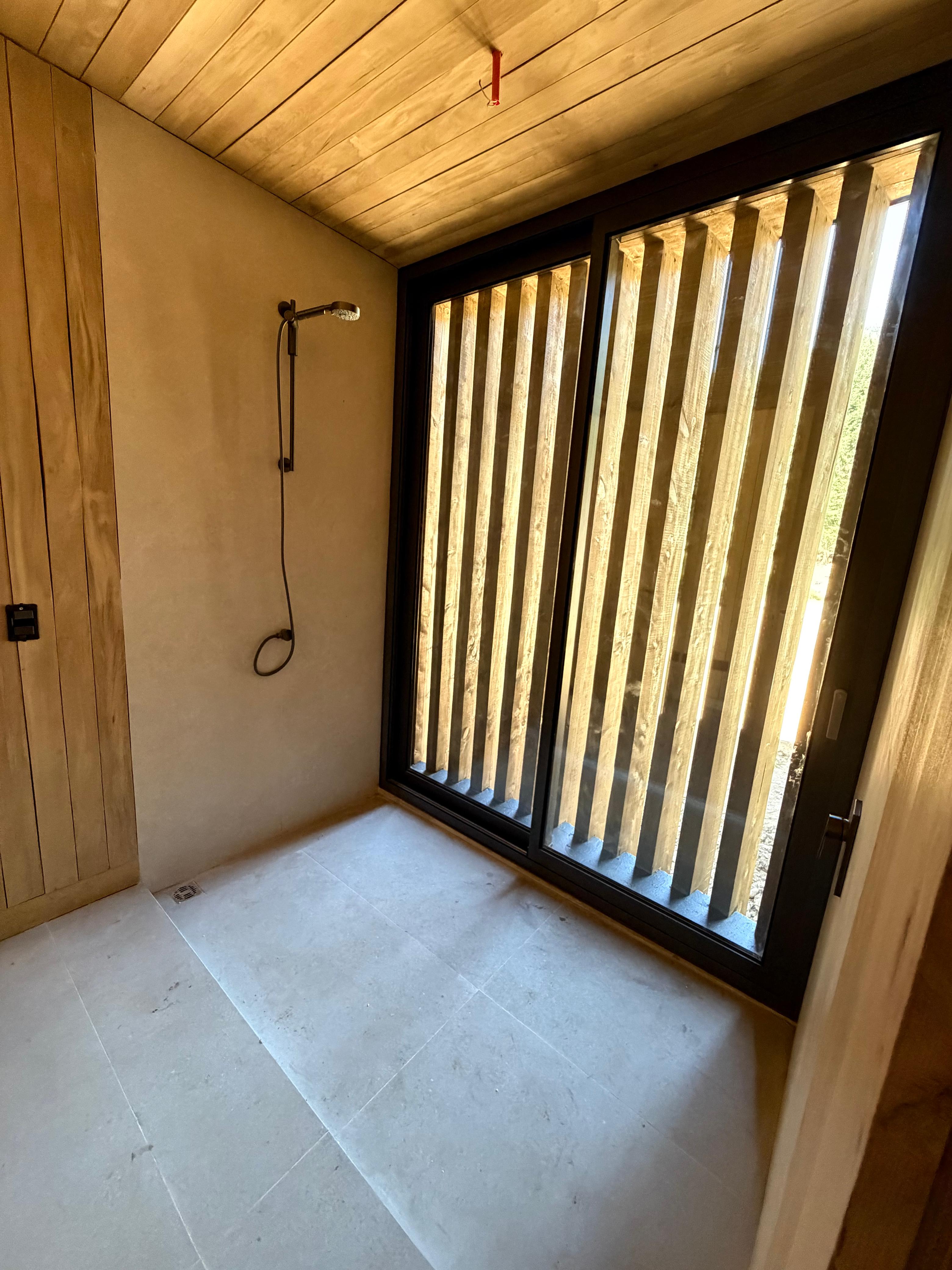 Trabajador instalando planchas de siding de fibrocemento en fachada de casa