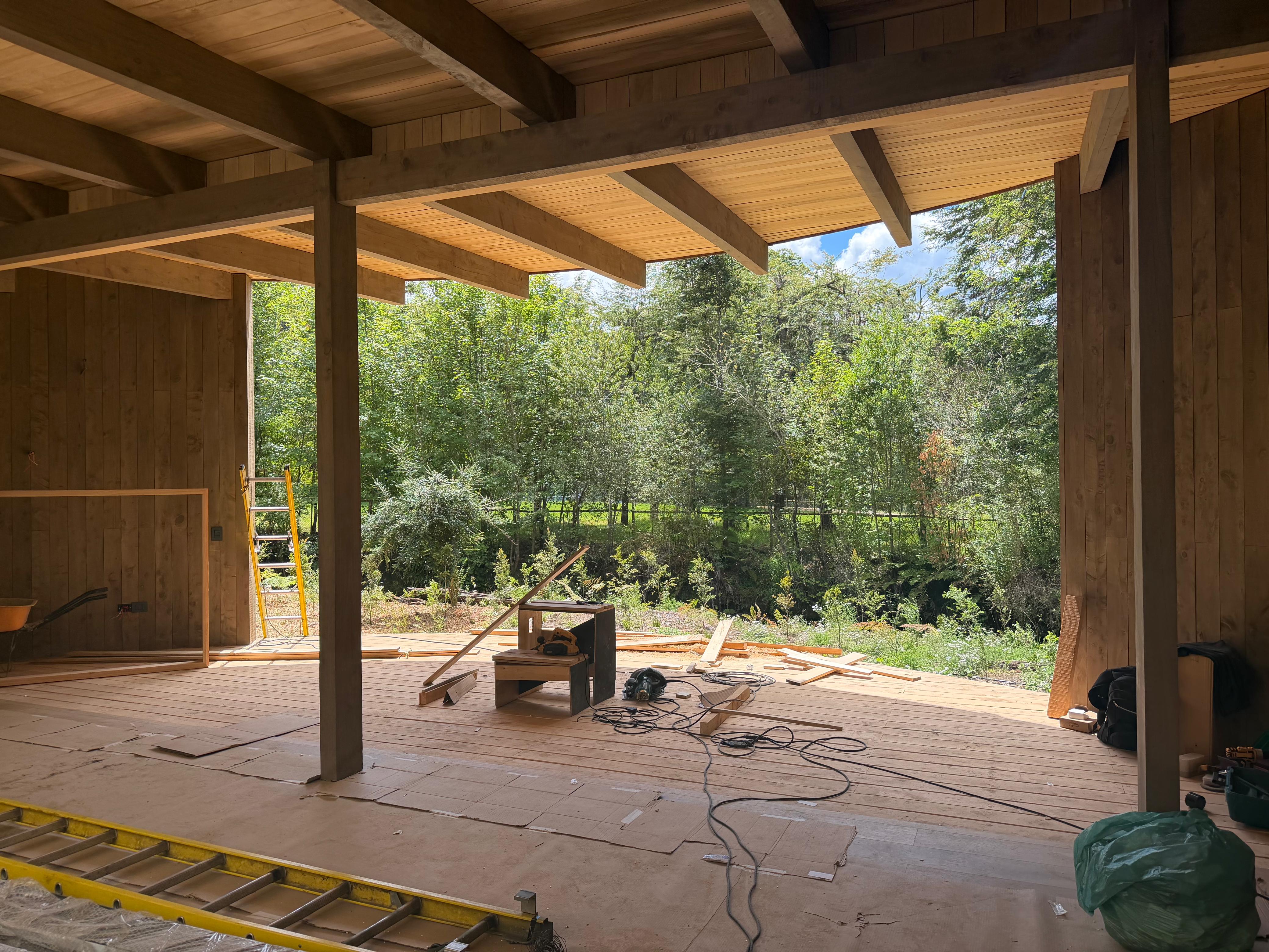 Interior de casa en obra con revestimiento de madera en el cielo y muros