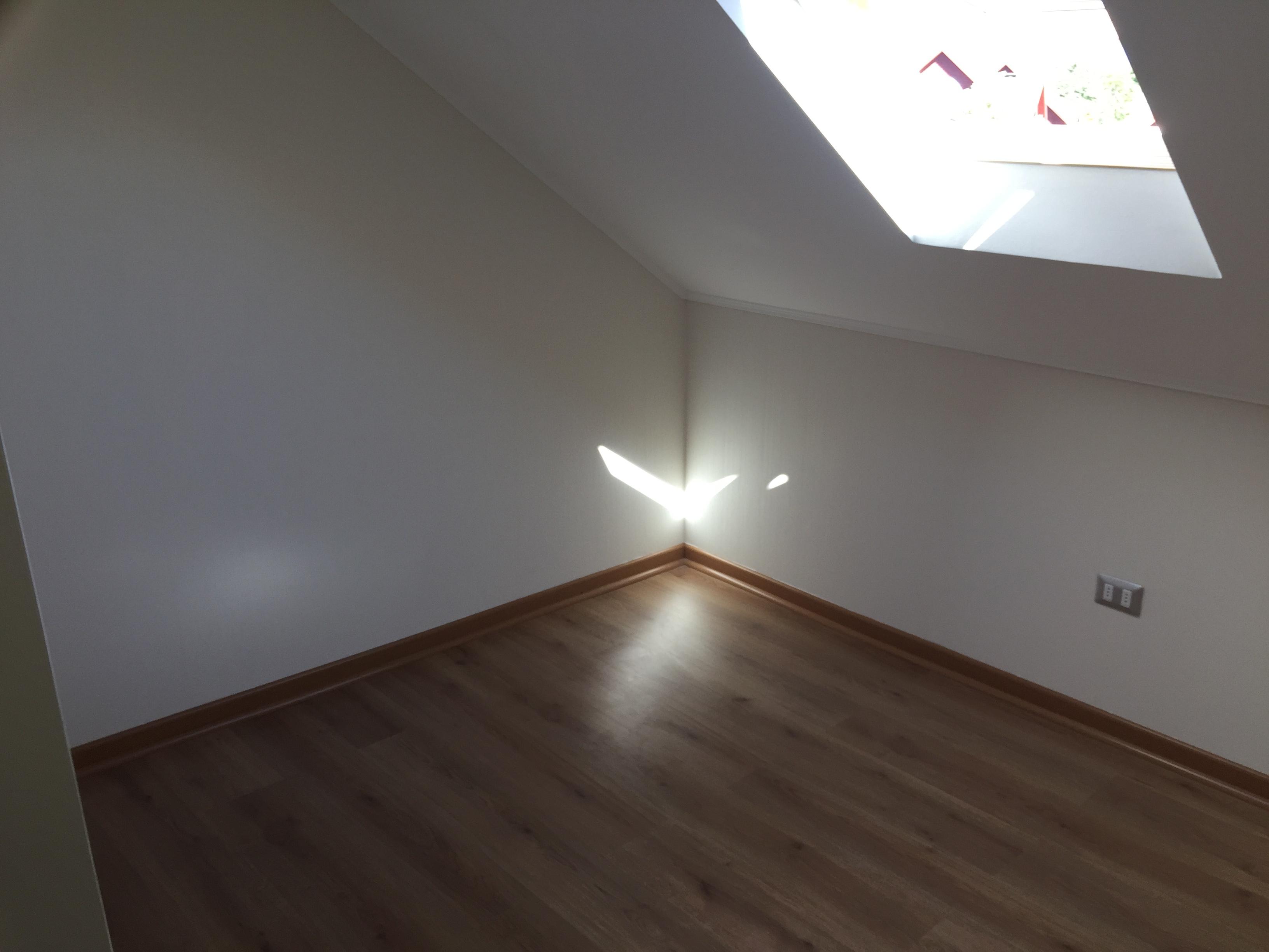 Esquina interior de habitación con muros blancos lisos y guardapolvos a juego